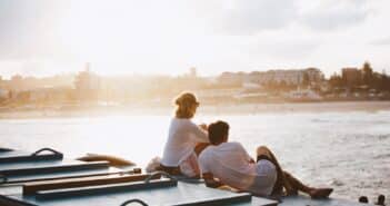 un couple assis devant un fleuve