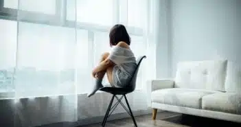 une femme assise devant sa fenêtre